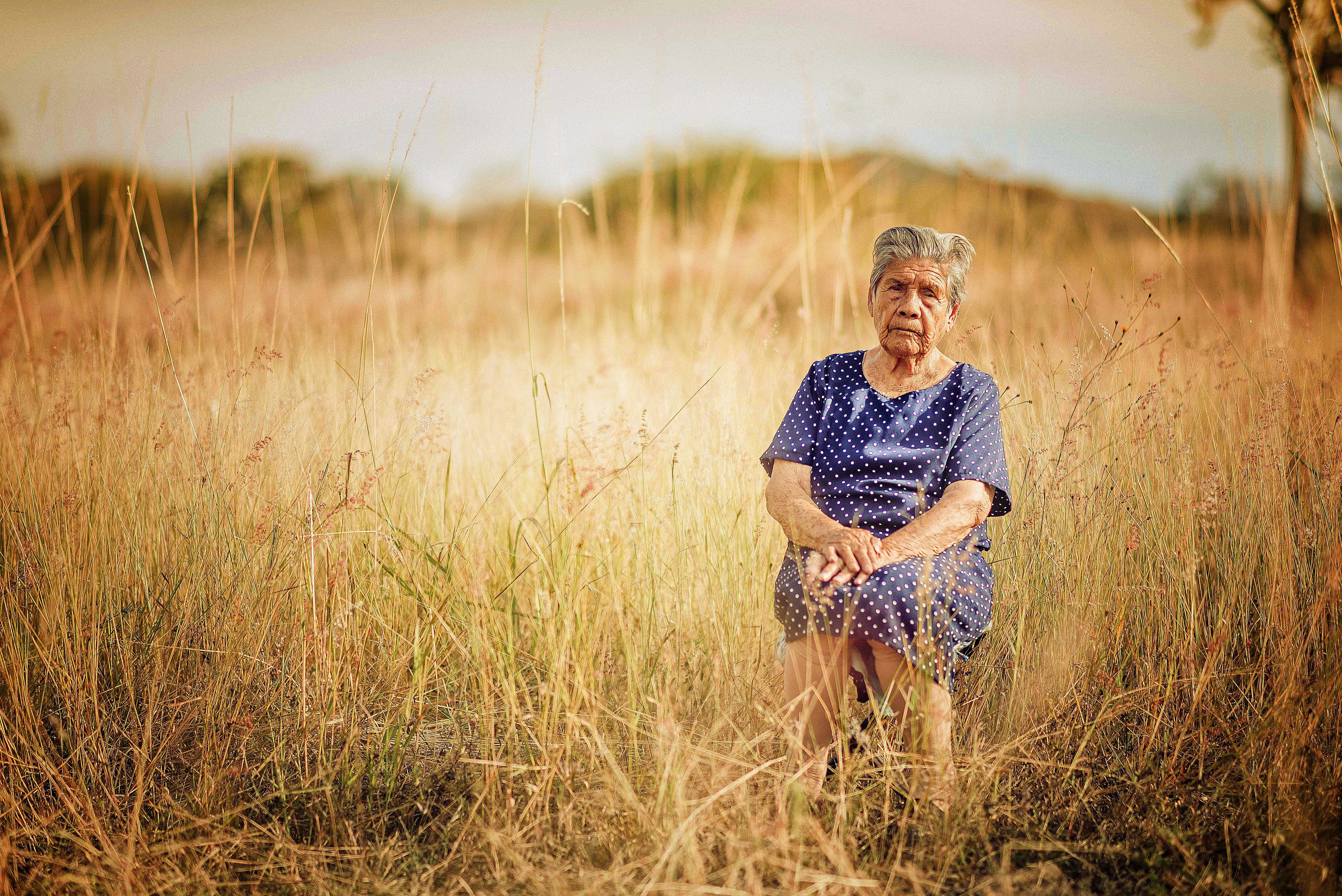 woman sitting on chair and surrounded by grass